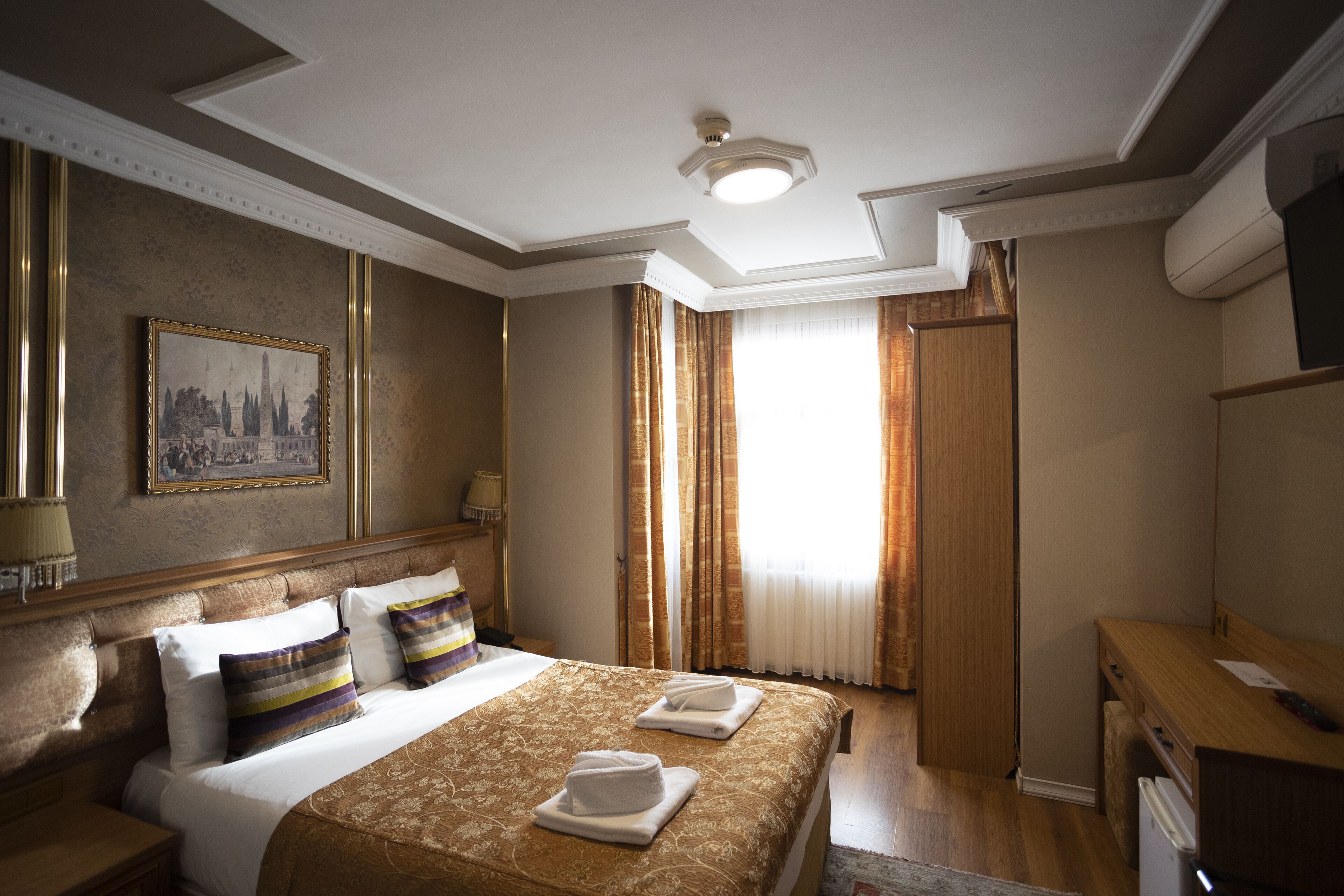 Une chambre d’hôtel avec un grand lit, un bureau et une télévision.