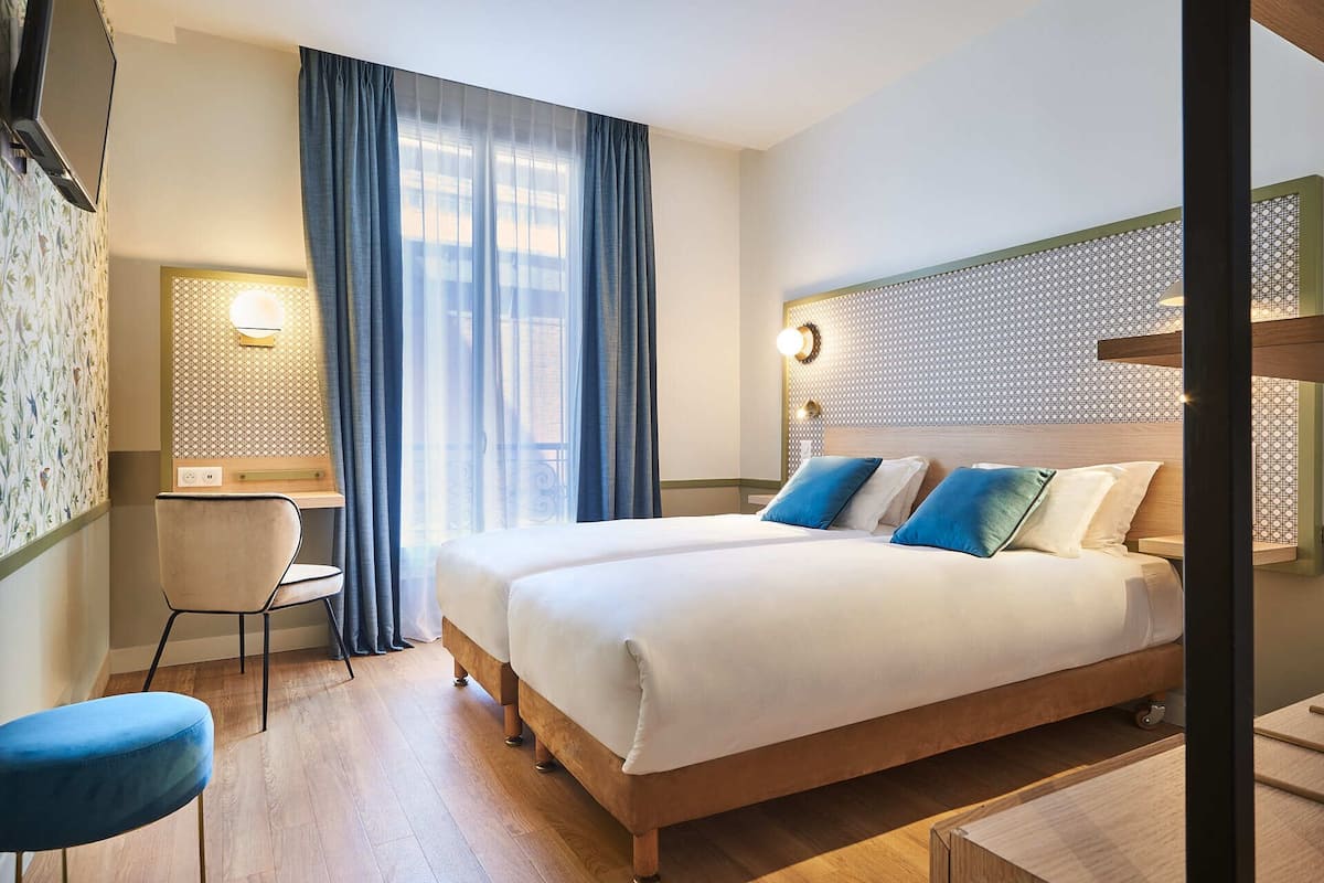 Een hotelkamer met een groot bed, een bureau en een stoel.
