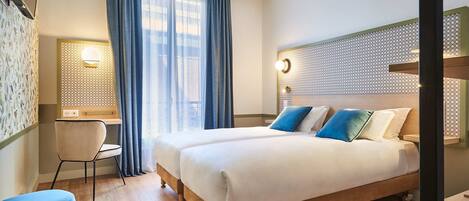 Ett hotellrum med en stor säng, ett skrivbord och en stol.