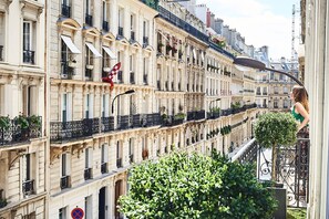 A row of historic buildings with balconies and a pedestrian walkway.