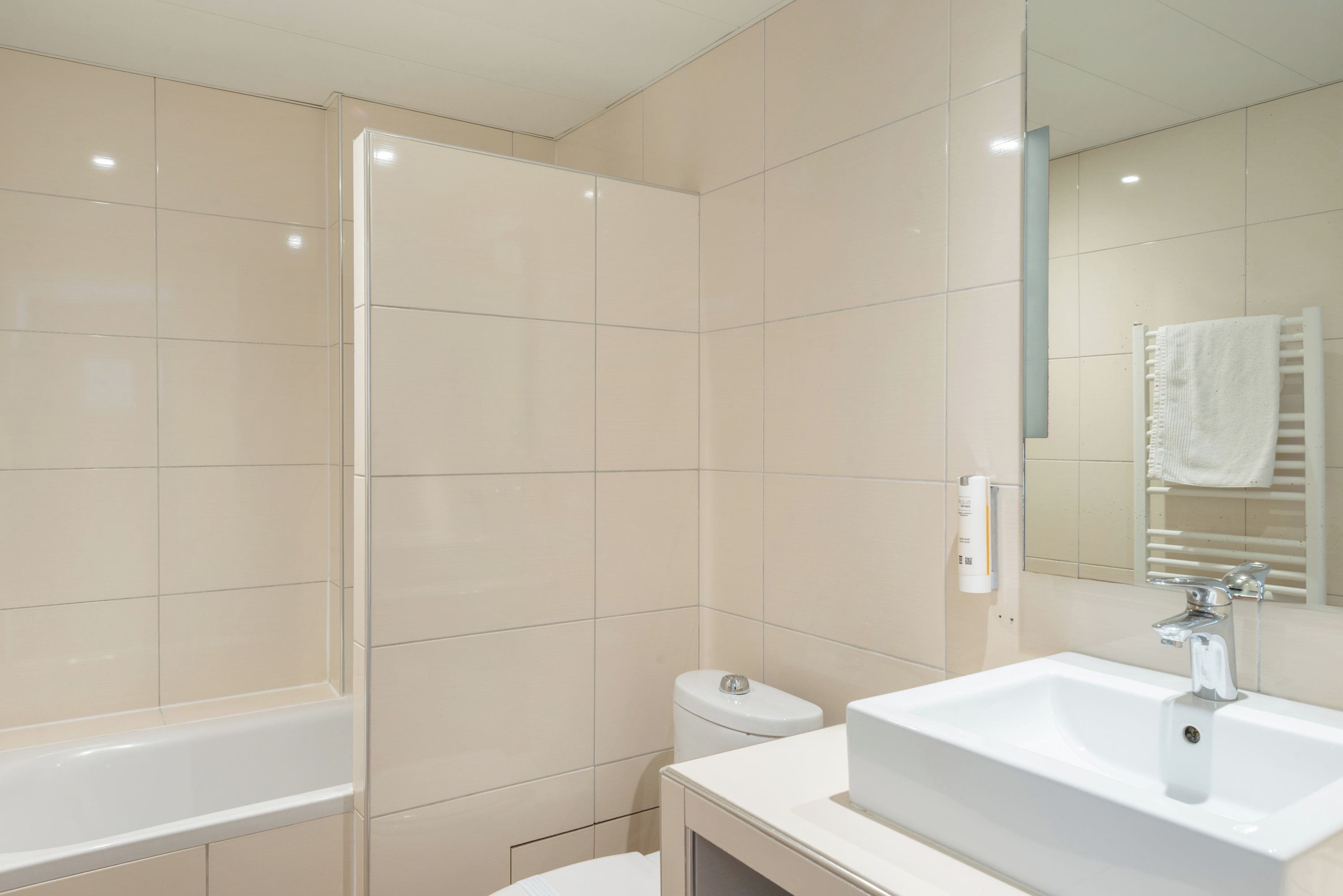 A modern bathroom with a bathtub, toilet, and sink.
