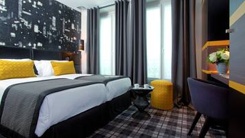 Habitación de hotel con una cama grande, una mesita, una silla y vistas a la ciudad desde la ventana.