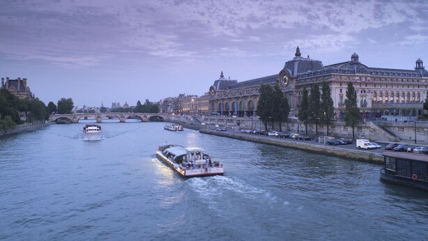 Une rivière avec des bateaux et un pont.