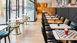 Un café moderne doté d’une salle intérieure, de grandes fenêtres et d’un comptoir bien visible.