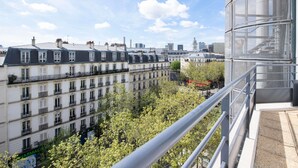 Une vue sur des immeubles parisiens dotés de balcons, avec un ciel dégagé.