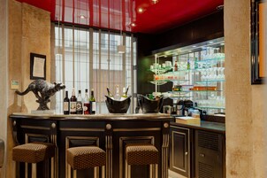 A bar area with a counter, stools, and shelves stocked with bottles and glasses.
