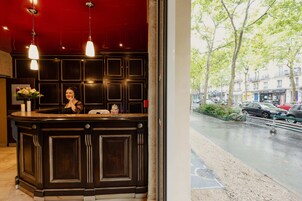 A reception desk with a dark wood finish and pendant lighting.