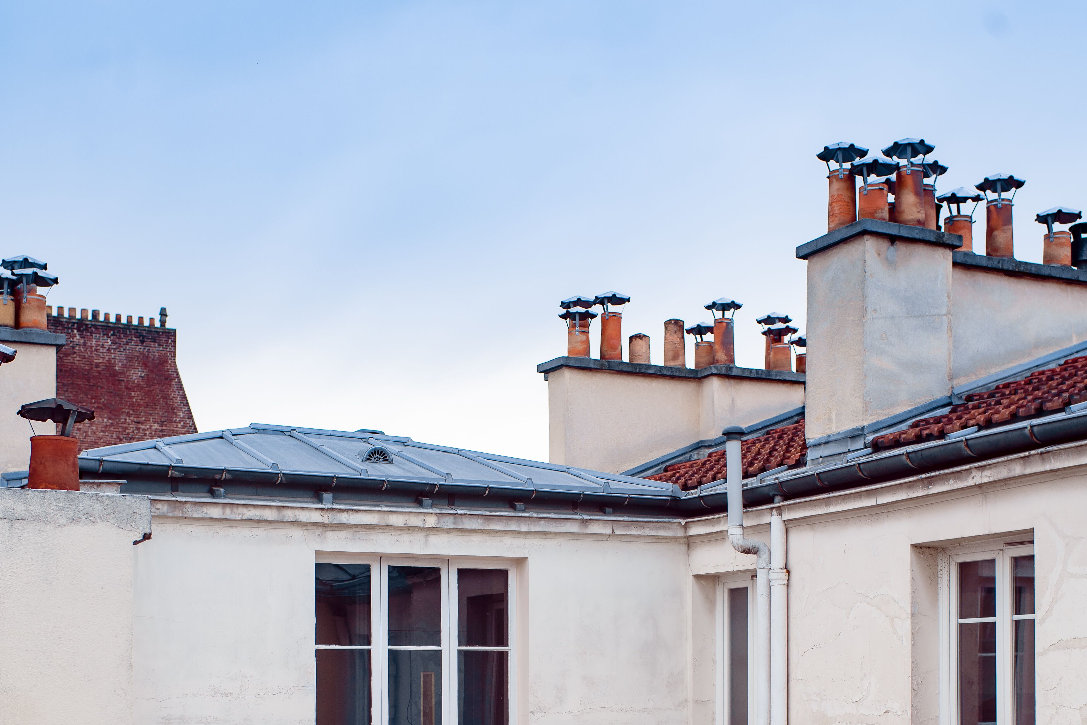 A building with multiple chimneys and a tiled roof.