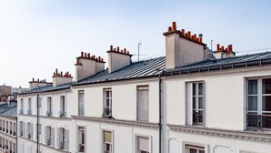 Uma fileira de edifícios brancos com várias chaminés e varandas.