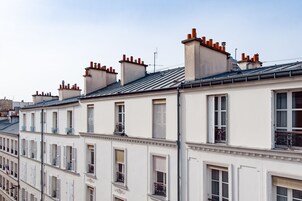Un hilera de edificios blancos con múltiples chimeneas y balcones.