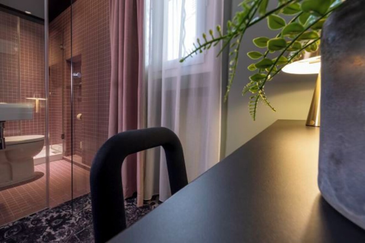 Un bagno moderno con cabina doccia in vetro, un water e un lavandino.