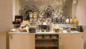 Un banco colazione con diversi cibi, condimenti e bevande.