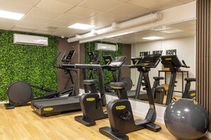 A gym with treadmills, elliptical machines, and a large exercise ball. - Europe Hotel Paris Eiffel (Paris)