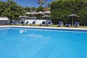 Una piscina al aire libre, sombrillas