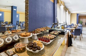 Uma área de buffet com diversos alimentos e um espaço para café.