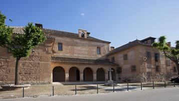 Un edificio histórico con patio, pasajes de arco y fachada de piedra.