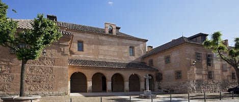 A historic building with a courtyard, arched passageways, and a stone facade.