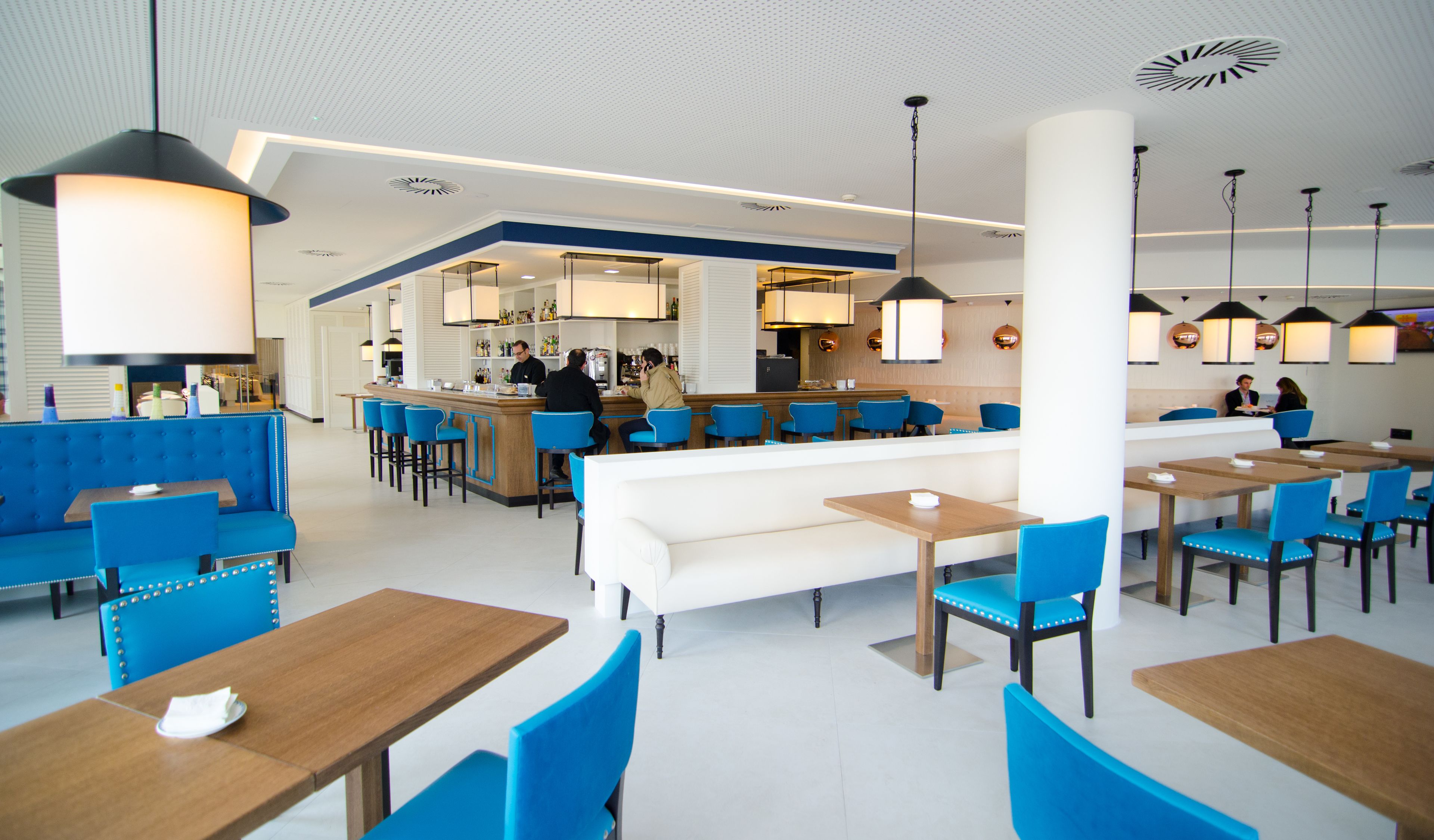 A modern hotel lobby with a bar area, seating arrangements, and a reception desk.