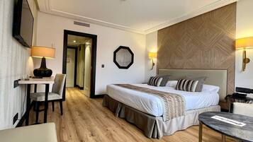 Una habitación de hotel con cama, mesitas de noche, escritorio y una silla.