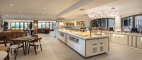 A modern dining area with a buffet counter, wooden chairs, and a large window providing a view of the outdoors.