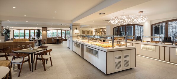 Un comedor moderno con mostrador de buffet, sillas de madera y un gran ventanal con vistas al exterior.