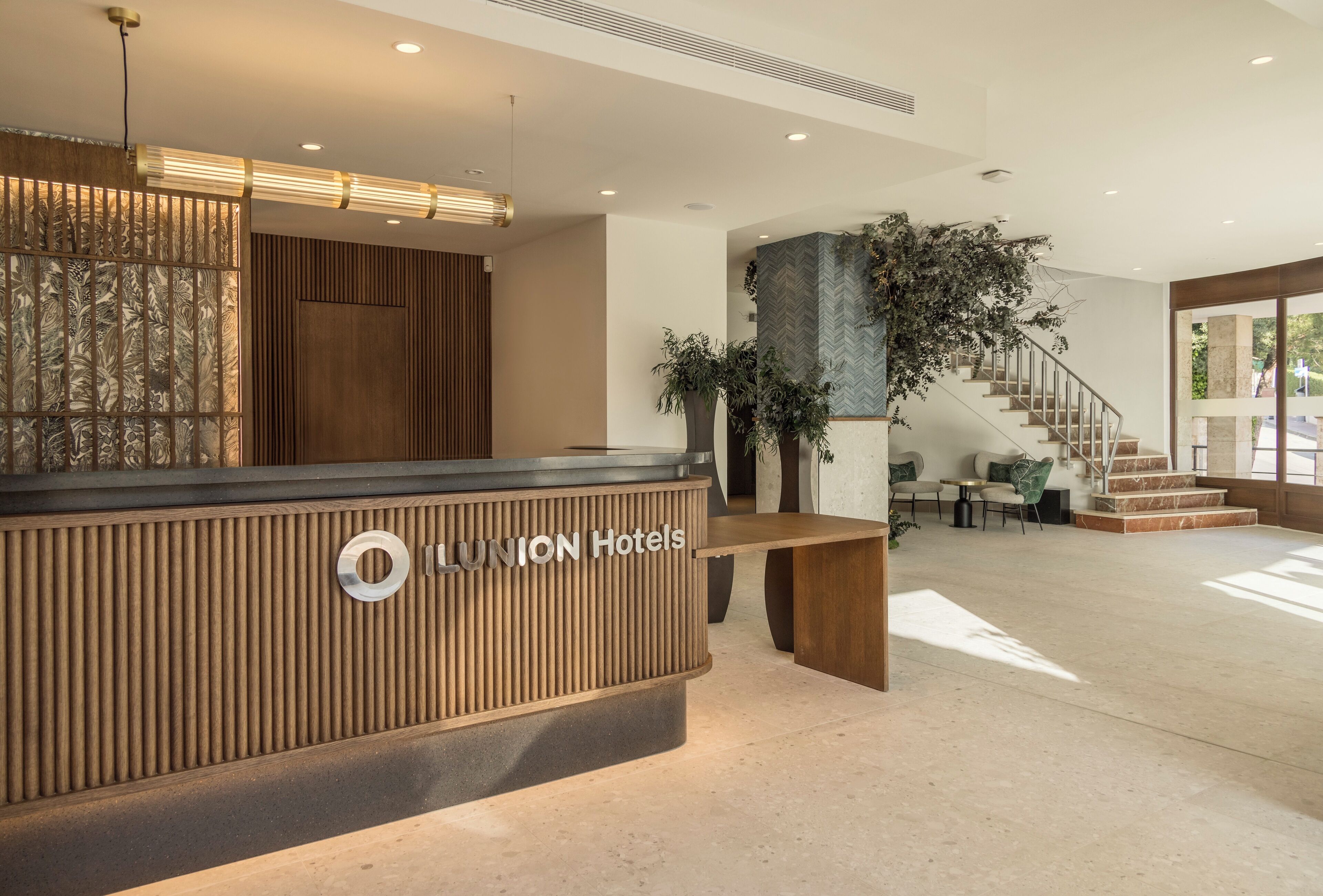 A reception desk with a modern design, a staircase, and a seating area.