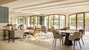 Un espace intérieur spacieux comprenant une grande table et des chaises, un canapé et une plante en pot.