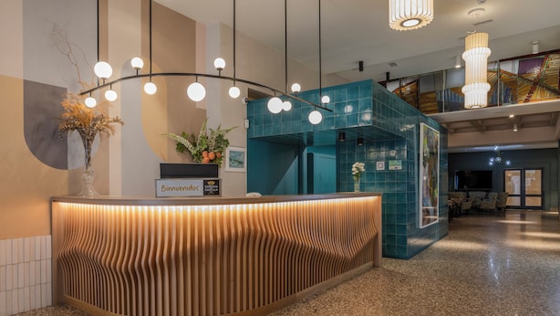Un mostrador de recepción de diseño moderno, un letrero con la inscripción "Bienvenue 105" y una escalera al fondo.