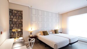 A hotel room with two beds, a desk, a chair, a bookshelf, and a large window. - Hotel Ciudad de Vigo (Vigo)