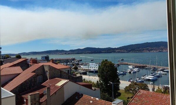 A marina with boats docked, a view of the water, and buildings with red-tiled roofs. - Hotel Ciudad de Vigo (Vigo)