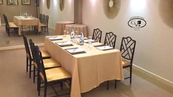 A conference room with a long table, chairs, and a logo on the wall.