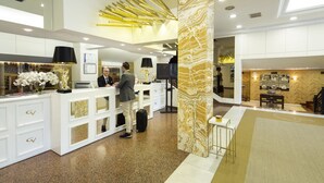 A hotel reception area with a modern design, featuring a reception desk, a large column, and a seating area. - Hotel Ciudad de Vigo (Vigo)