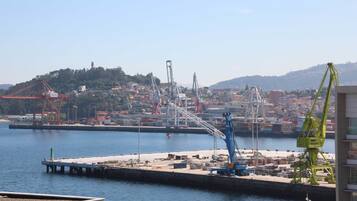 A waterfront port with cranes and a bridge in the background.