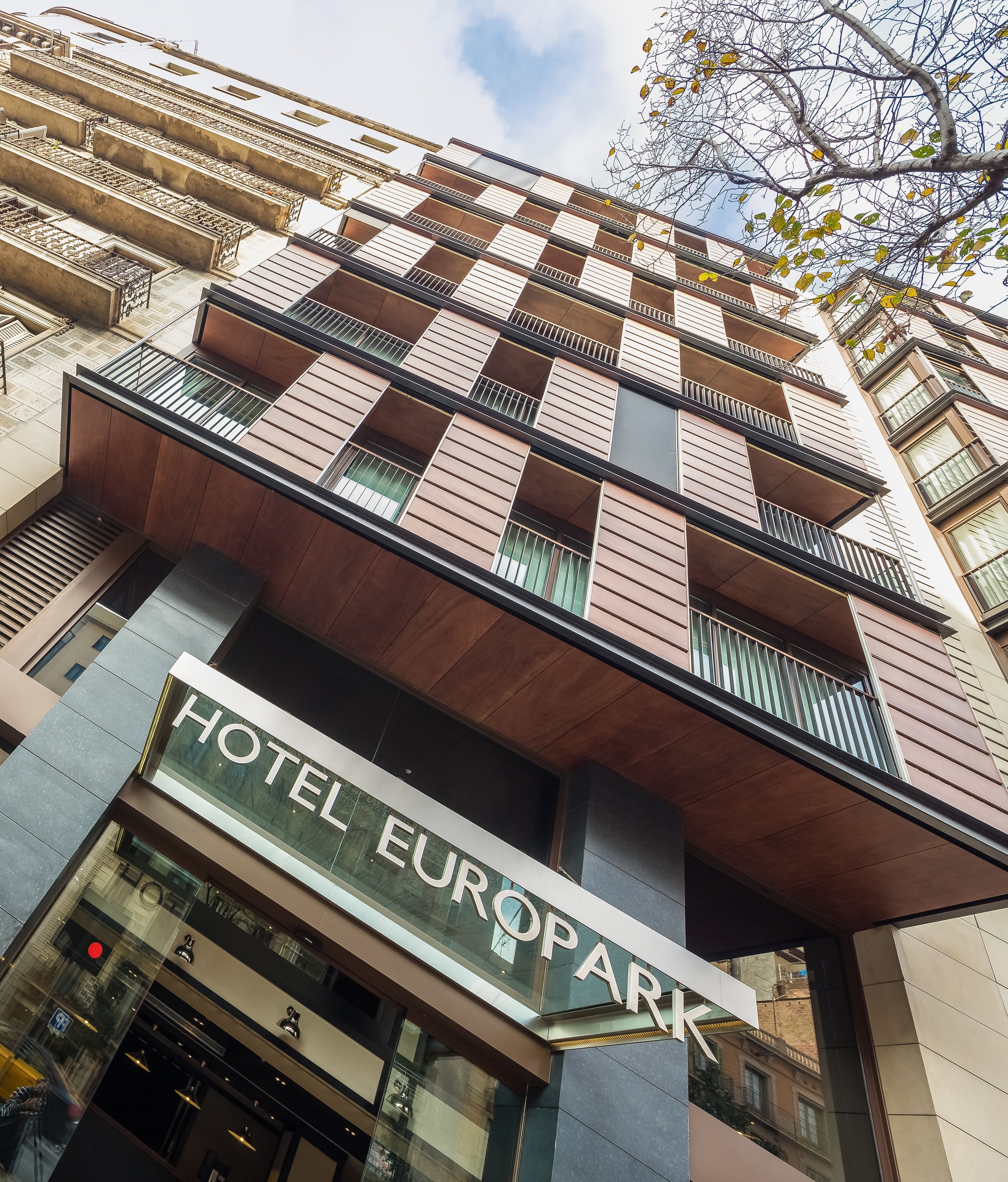 A modern hotel with a prominent 'HOTEL EUROPARC' sign, featuring a unique architectural design with balconies and a mix of materials.