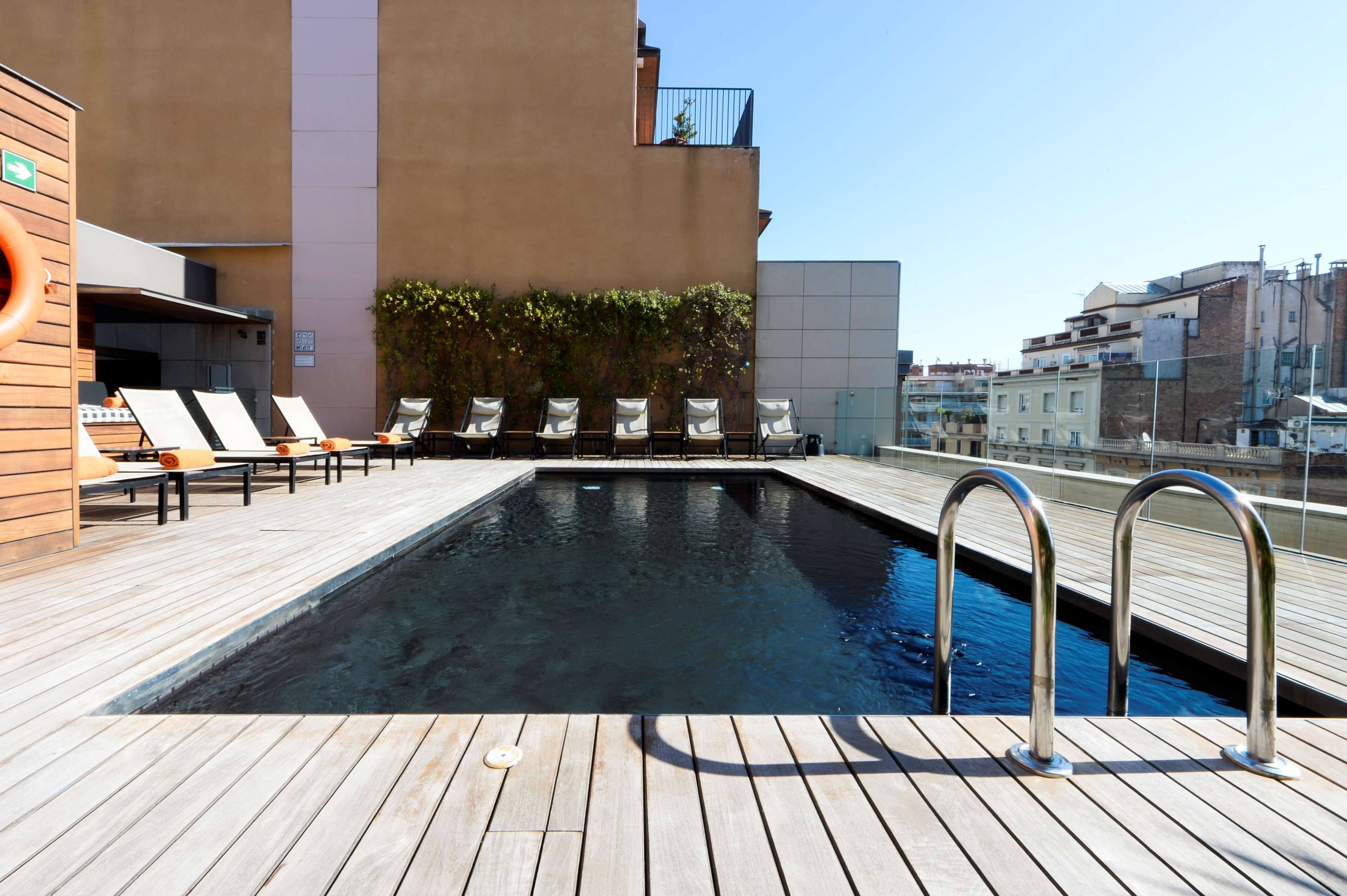 A rooftop pool area with lounge chairs and a small pool.