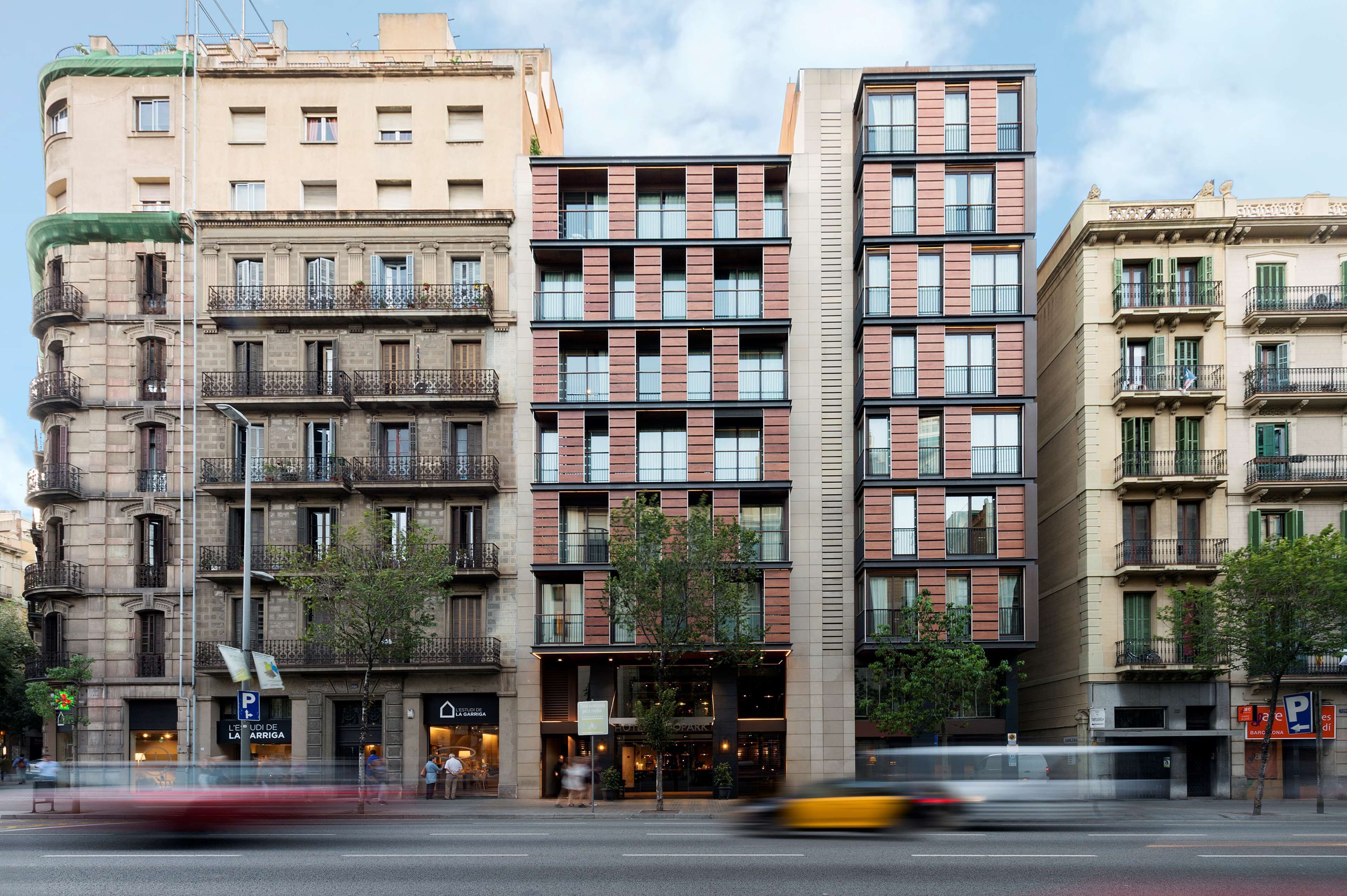 A multi-story building with a central entrance, balconies, and a mix of architectural styles.