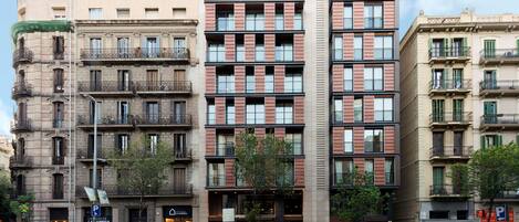 Un edificio de varios pisos con entrada central, balcones y una mezcla de estilos arquitectónicos.