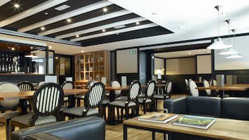 Um restaurante moderno com cadeiras listradas, um bar e uma estante de livros.