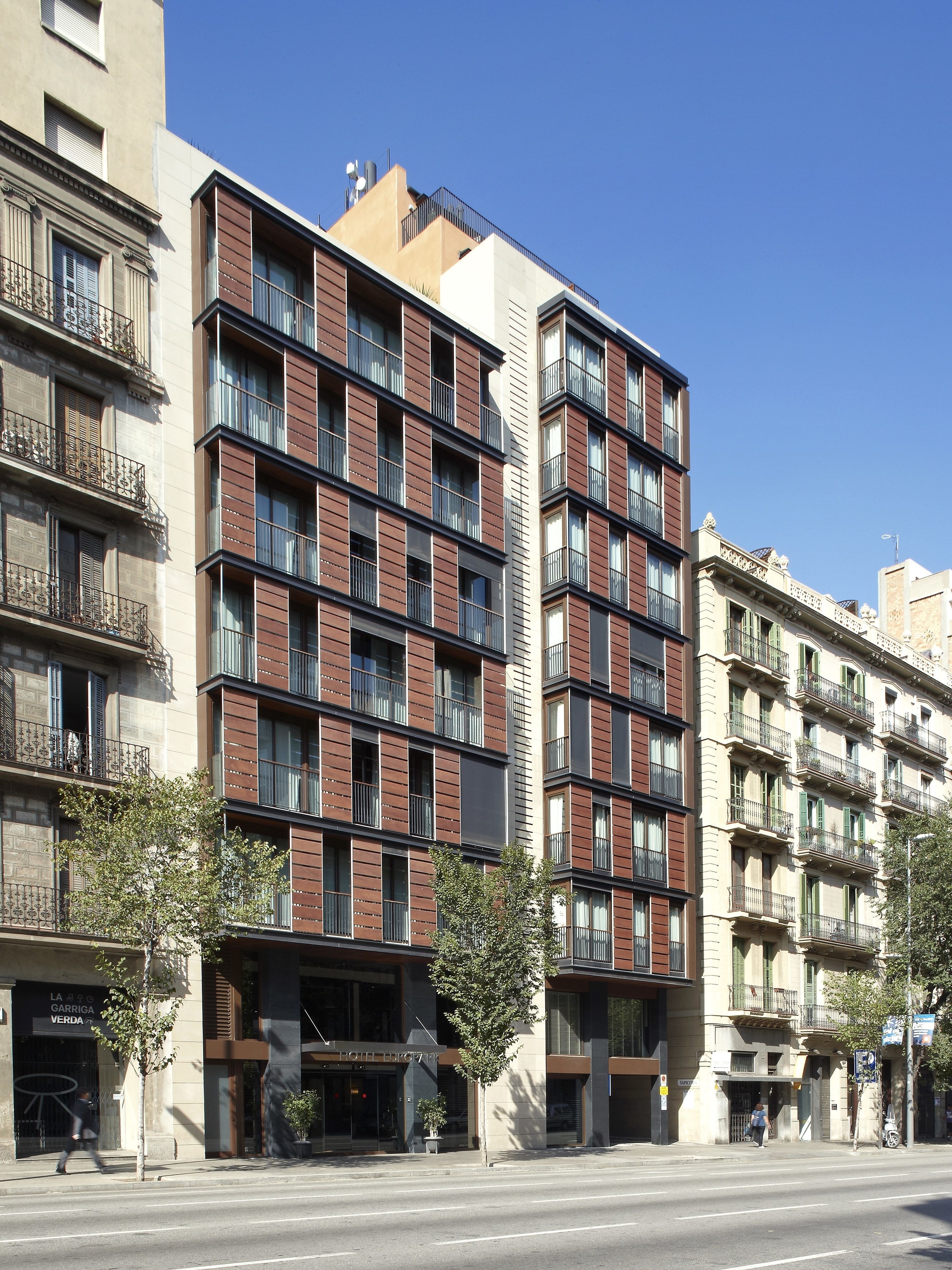 A multi-story building with a modern facade, featuring a mix of brick and glass elements.