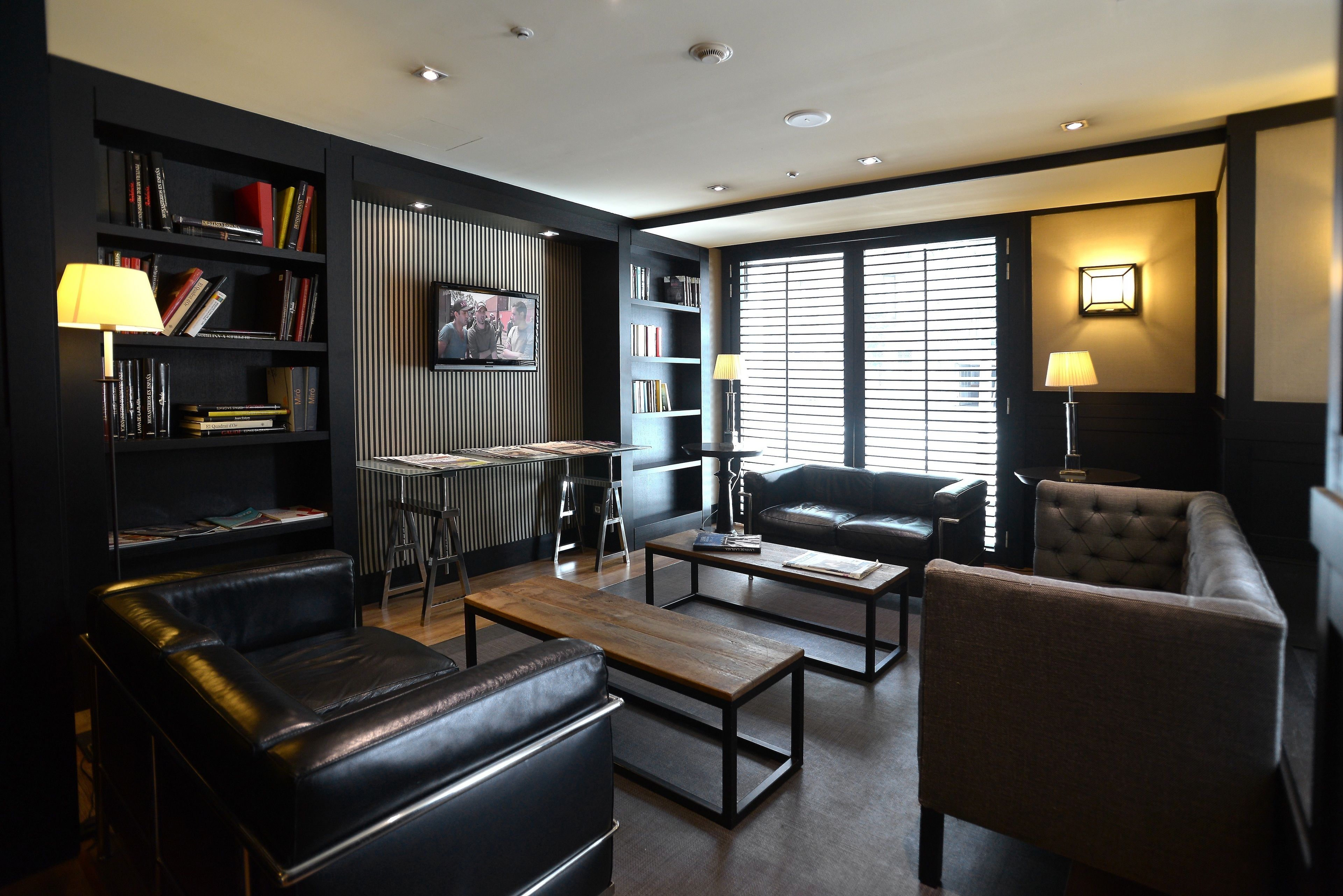 A modern living room with a leather sofa, a wooden coffee table, and a bookshelf.