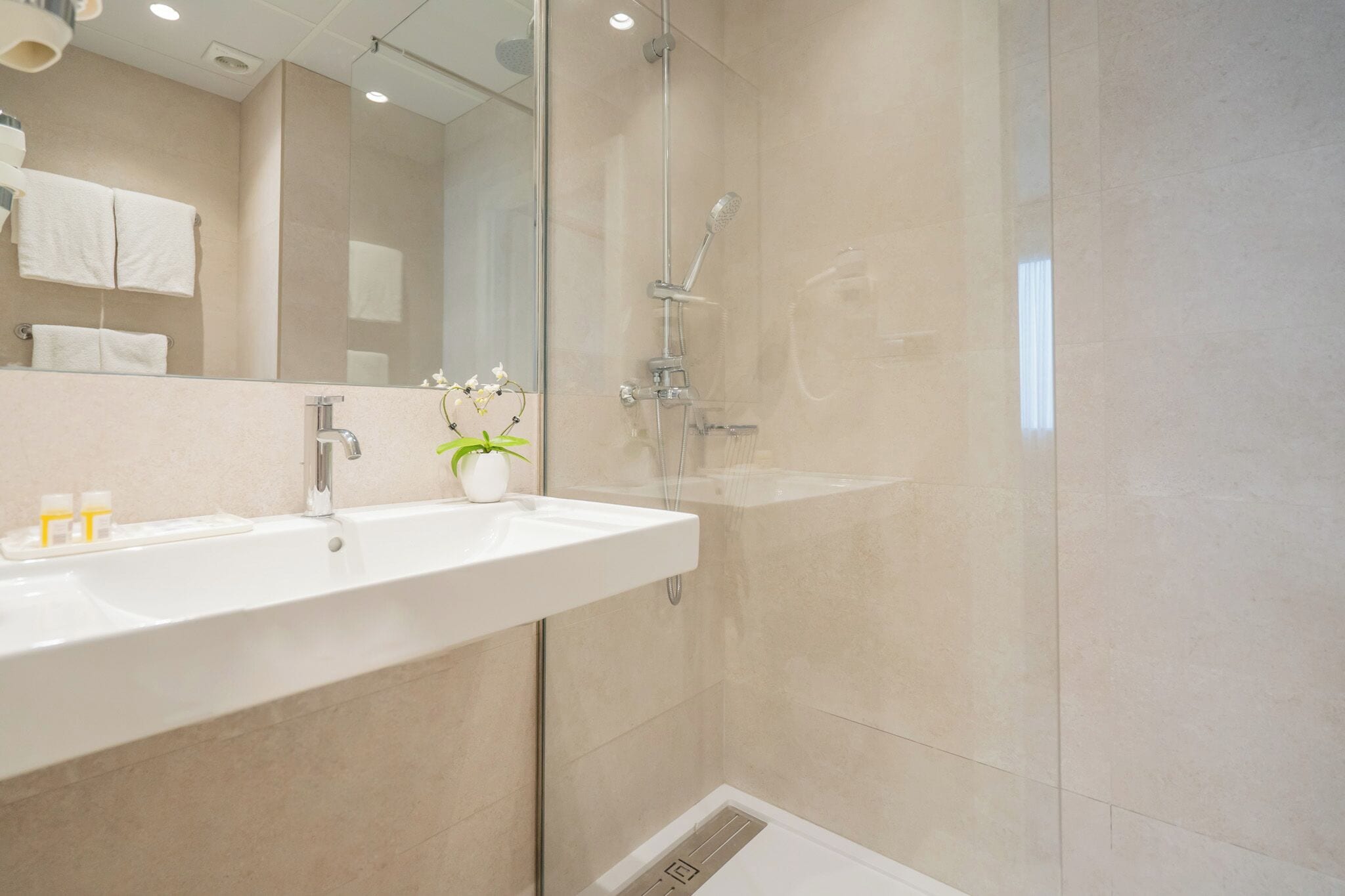 Standaard tweepersoonskamer | Badkamer | Een bad/douchecombinatie, een haardroger, een bidet, handdoeken
