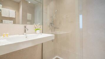 Standaard tweepersoonskamer | Badkamer | Een bad/douchecombinatie, een haardroger, een bidet, handdoeken