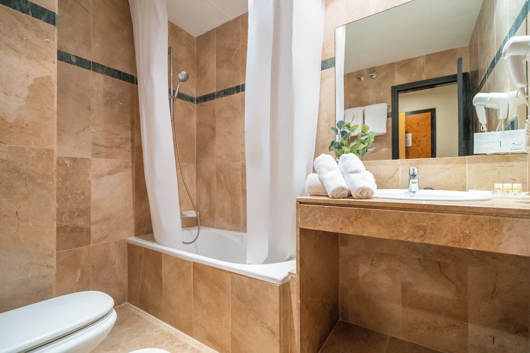 A bathroom with a bathtub, toilet, and sink.