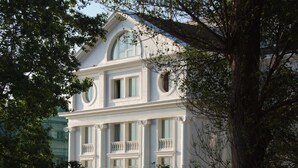 A large, white building with multiple balconies and a curved entrance. - Hotel Hoyuela (Santander)