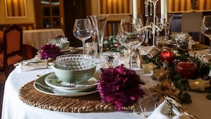 A table set for a meal with clear glassware, a bowl, and decorative elements like flowers and fruits. - Hotel Hoyuela (Santander)