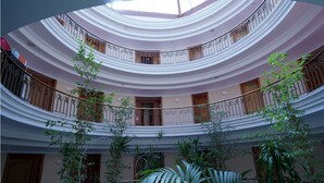 A multi-level atrium with balconies and indoor plants. - Hotel Hoyuela (Santander)