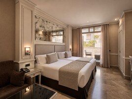 Habitación de hotel con una cama grande, un escritorio con teléfono y vistas al exterior.