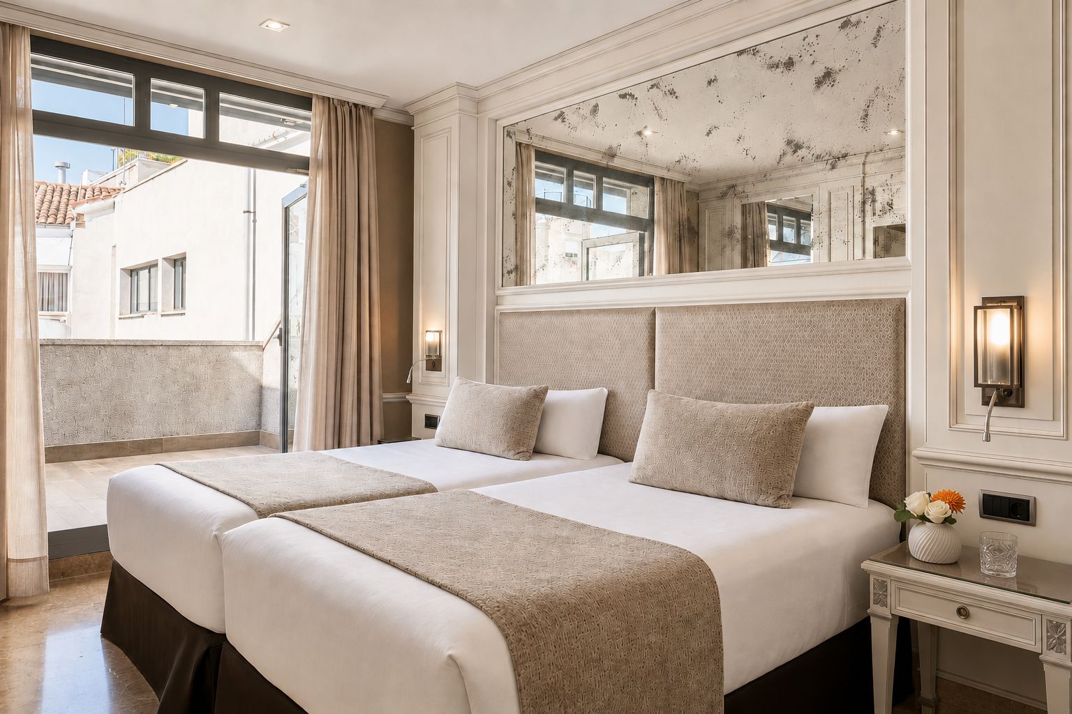 Una habitación de hotel con una cama grande, una mesita de noche, un espejo y una ventana con cortinas.