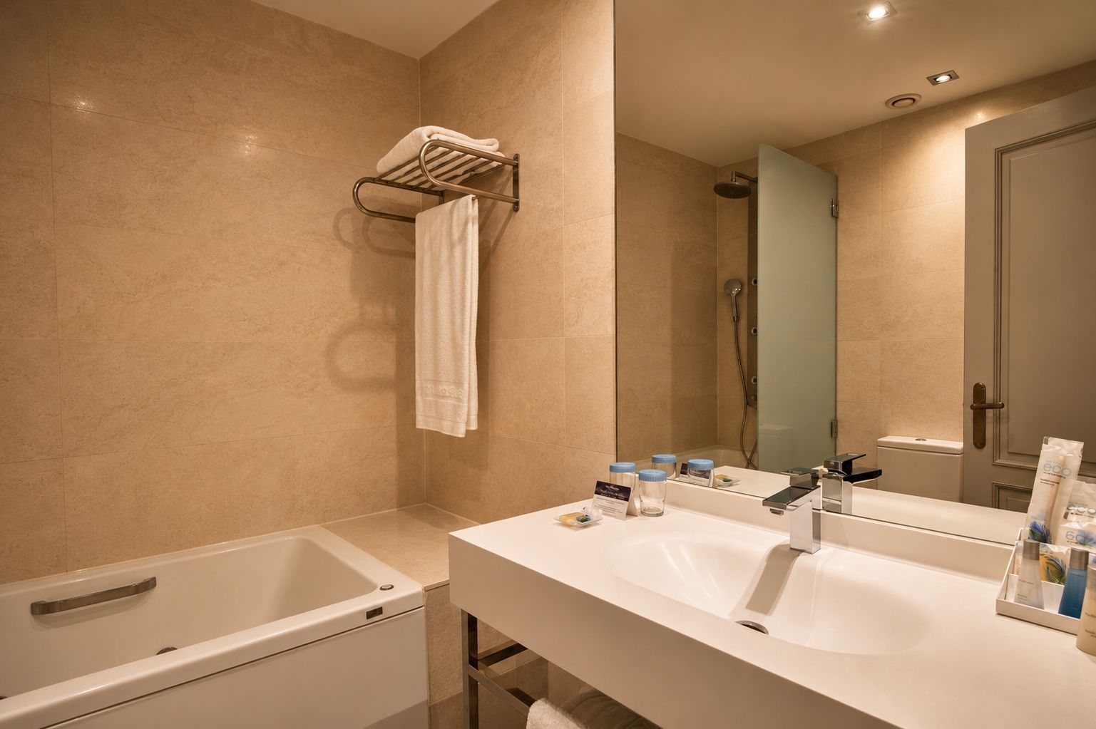 A modern bathroom with a bathtub, two sinks, and a shower.