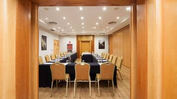 Un salón de conferencias con una larga mesa, sillas y techo de madera.